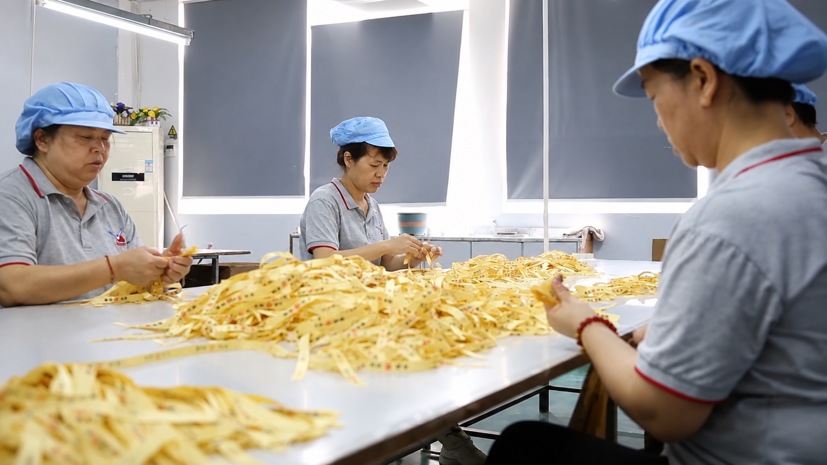 Workers hand-sorting finished ribbons — quality inspection