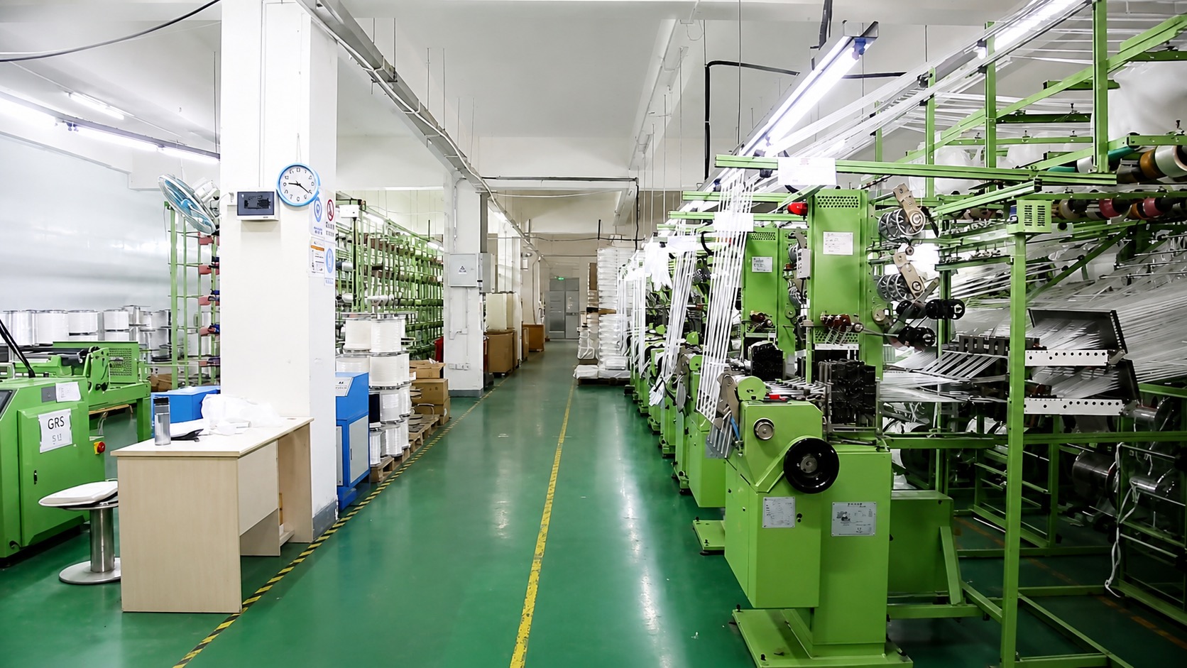 Narrow loom weaving hall — rows of green ribbon weaving machines