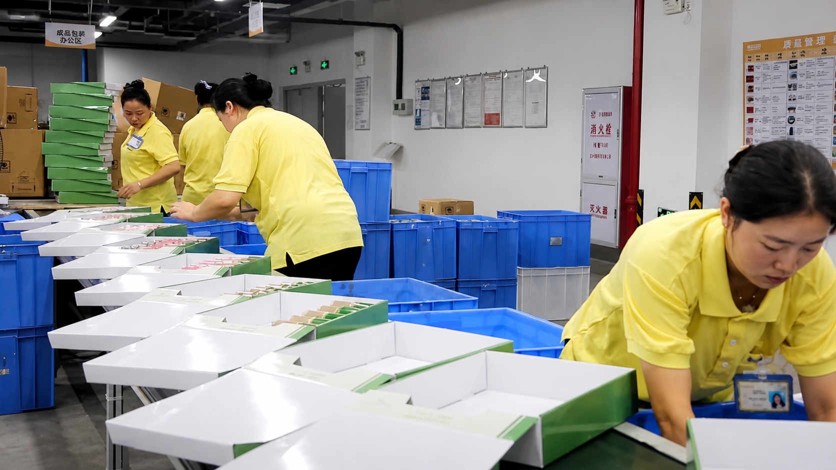 Finished product packaging area — workers packing ribbon export boxes